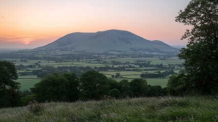 Sunset over the rolling hills of the English countryside, a picturesque landscape with a majestic mountain in the background