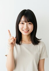 Beautiful Asian woman standing straight pointing her hand up because she got an inspiring idea to solve life's problems