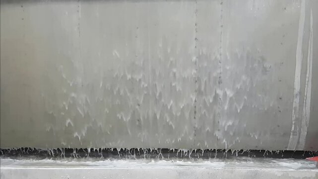dirty liquid drops flowing at the metal sheet
