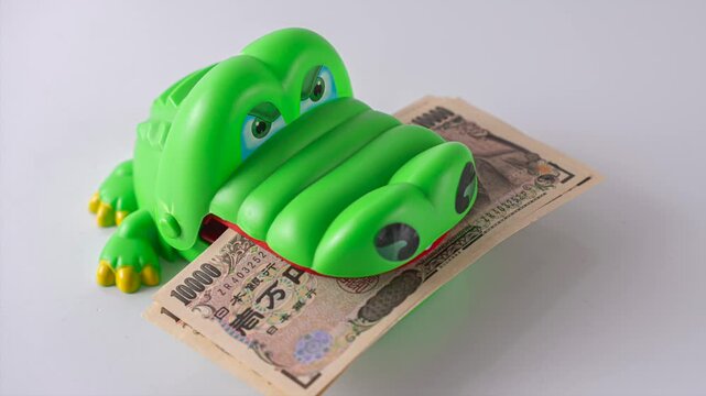 1万円札を咥えるワニ