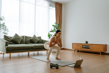 Young Asian beautiful woman doing aerobic exercise at home. Attractive girl doing  workout by...