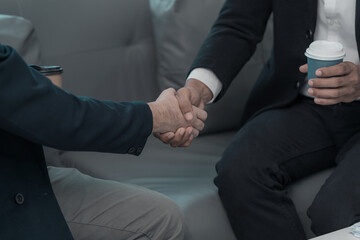 Fototapeta premium Concept of business negotiation and handshake to show connection between people in making deal with close up photo of business partners shaking hands.