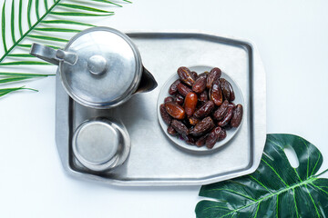 Top View Of Dates Fruit With Tea Pot Set On Stainless Tray Over White Background