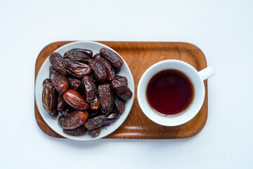 Top View Of Dates Fruit And Hot Tea Served On Wooden Tray With White Background