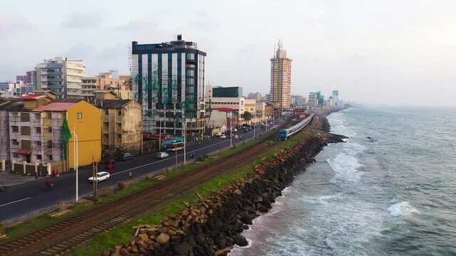 Aerial view of train on railway tracks along the ocean in the city of Colombo. Sri Lanka