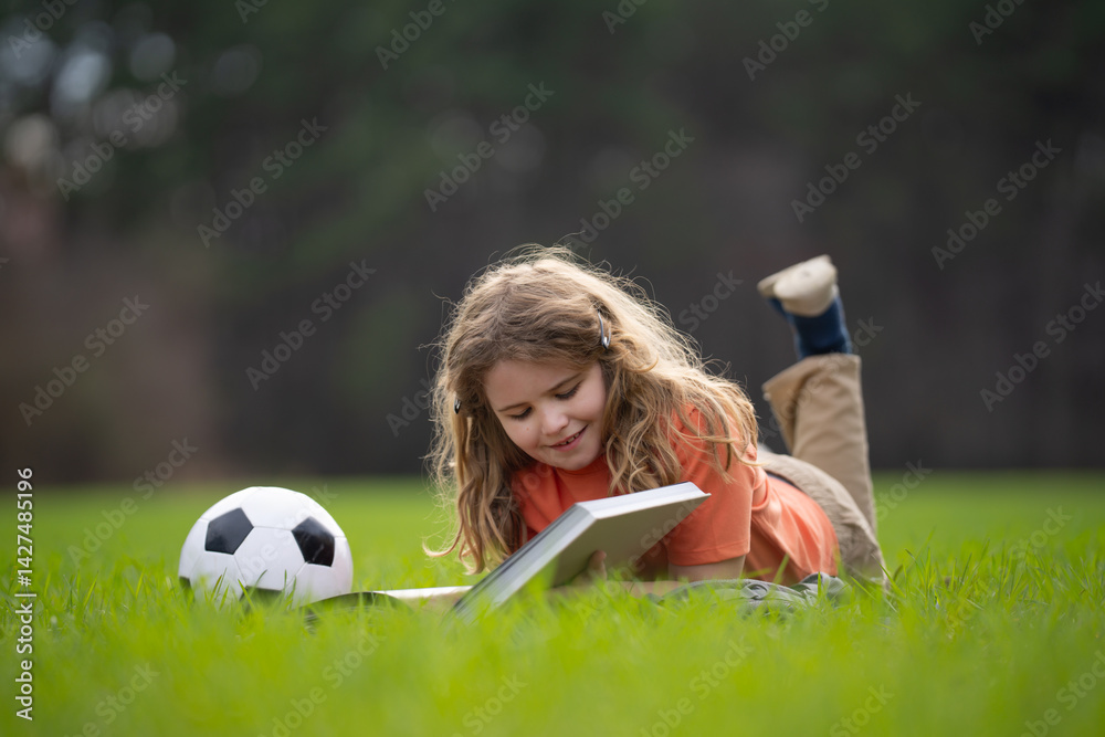 Poster child reading a book in the grass. kid enjoying a book story outdoors. child studying with book in t