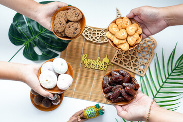 Top View Of Hands Offering Various Sweet Snacks For Iftar Time On Ramadan
