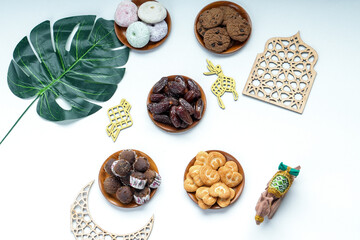 Flat Lay Of Dates Fruit And Various Cookies On Wooden Plate With Islamic Decoration