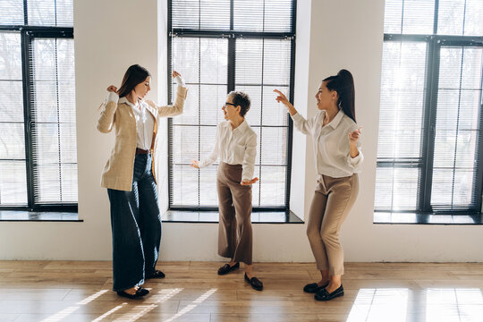 Businesswomen dancing together in the office celebrating success