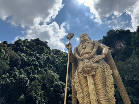 Selangor, Malaysia - April 20th 2025 : Batu caves a golden statue of murugan shines brightly