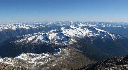 Breathtaking aerial view of rugged snow capped mountain range under clear blue sky ideal for travel and adventure themes