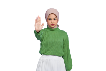 Beautiful serious Asian woman in a green sweater standing with outstretched hand showing stop gesture isolated on transparent background