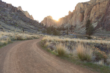 Desert road winding through canyon at sunset