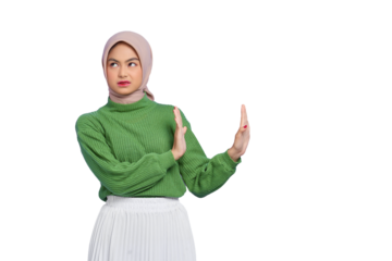 Beautiful annoyed Asian woman in green sweater makes stop gesture, demonstrates rejection isolated on transparent background