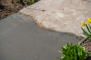 Continuing to pour concrete on the path. Freshly poured concrete is connected to the old concrete