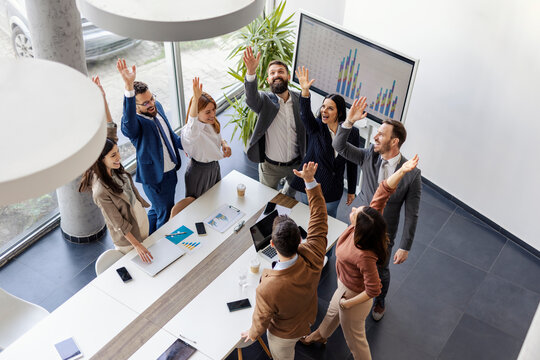 Top view of successful group of leadership team celebrating success and achievement at boardroom.