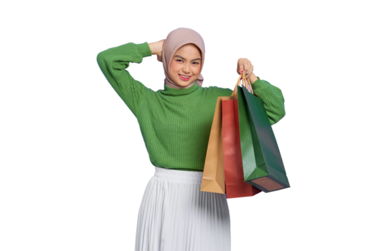 Beautiful young Asian woman in green sweater holding shopping bags and scratching head with hand isolated on transparent background