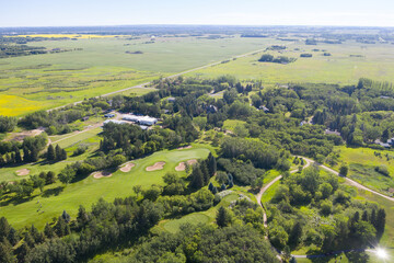 Fototapeta premium Golf course with a green field and trees in the background