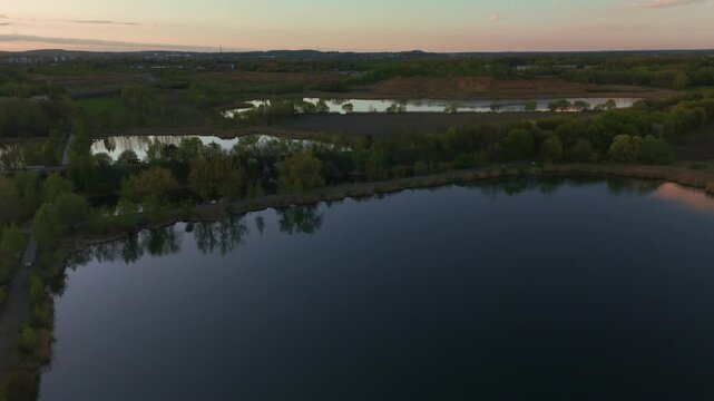 Backward motion above lake under golden sky
rone flying slowly backward above reflective lake.