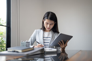 Obraz premium Happy young Asian Woman Successful Business woman creative using digital tablet in office
