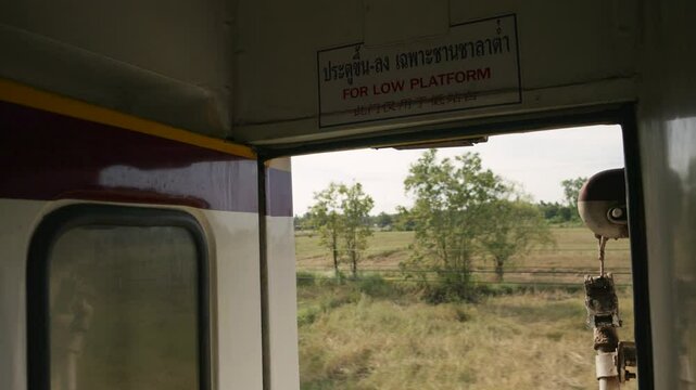 POV shot from train of landscape passing by from Thailand's Eastern Line from Bangkok to Ban Klong Luk during the day in Thailand, medium shot