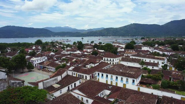 Drone rotating over quiet street in the Paraty town, mosty cloudy day in Brazil