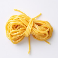 A bunch of uncooked spaghetti.  A tightly bound bunch of long, thin, yellow pasta strands rests on a white background.  The pasta is ready for cooking