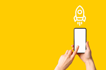 Person tapping smartphone screen with a rocket icon, ready for innovation