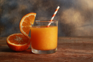 Glass of orange juice and fresh orange cut in half. Healthy drinking.