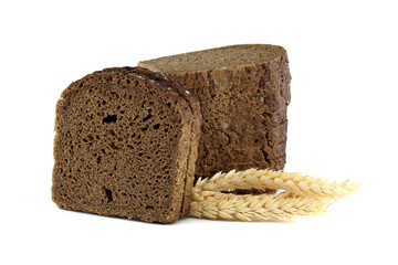 A rustic loaf of dark bread, freshly sliced, sits beside golden wheat stalks