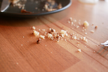 Crumbs scattered on a wooden table after enjoying a meal
