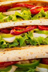Fresh vegetable sandwiches stacked on a wooden table