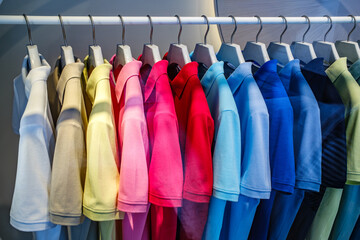 Colorful assortment of polo shirts hanging neatly on a clothing rack in a retail store showcasing various hues for shoppers