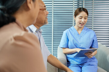 nurse or caregiver meeting and talking with about health with senior couple