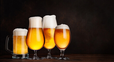 A selection of various beer glasses filled with draft beer