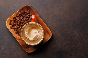 A steaming cup of freshly brewed coffee surrounded by rich, aromatic roasted coffee beans