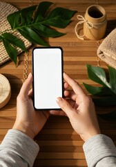 Hand holding a phone with a blank screen, natural green background