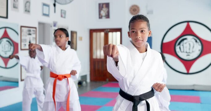 Group, karate and kids training in dojo for fight, fitness and learning self defense in class for sports. Students, children and practice martial arts for lesson, workout and punch for exercise