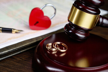 Divorce, end of Marriage Concept. Close-up of Wedding Rings, gavel, heart lock, and divorce document. Legal finality and lost love