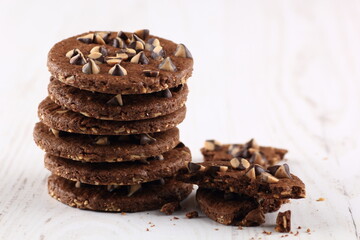 Chocolate Chip Cookies in a glass bowl and chocochips which is scattered under it
