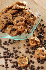 Chocolate Chip Cookies in a glass bowl and chocochips which is scattered under it