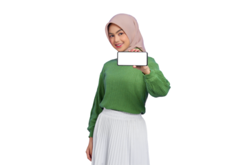 Smiling beautiful Asian woman in green sweater and hijab showing blank screen mobile phone isolated on transparent background