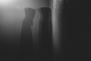 Fototapeta premium Dark hooded ghostly figure walks through dark wall