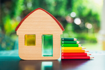 A model of a house with colored pencils ranging from green to red representing the energy levels in the house.Energy Efficiency Rating And House concepts.