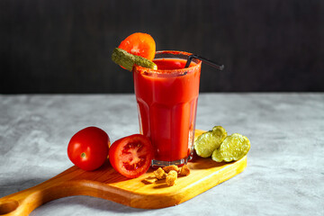 Refreshing vegetable cocktail. Tomato juice served in glass with tomatoes and pickles. Image for menu, bars, restaurants