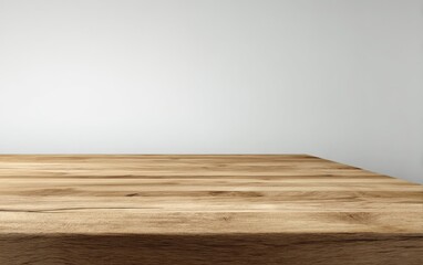 Light brown wooden table top against a light gray wall