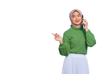 Cheerful beautiful Asian woman in green sweater and hijab talking on mobile phone while looking aside isolated on transparent background