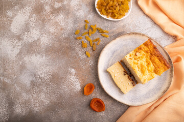 Сottage cheese Сasserole, Curd cake, with dried apricots and raisins on brown concrete, top view, copy space
