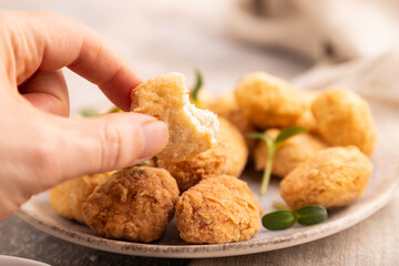 Fried crispy Chicken Nuggets with ketchup, microgreen on brown concrete with hand. Diet, healthy eating. side view, selective focus