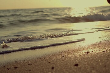 Gentle waves on golden sand at sunrise